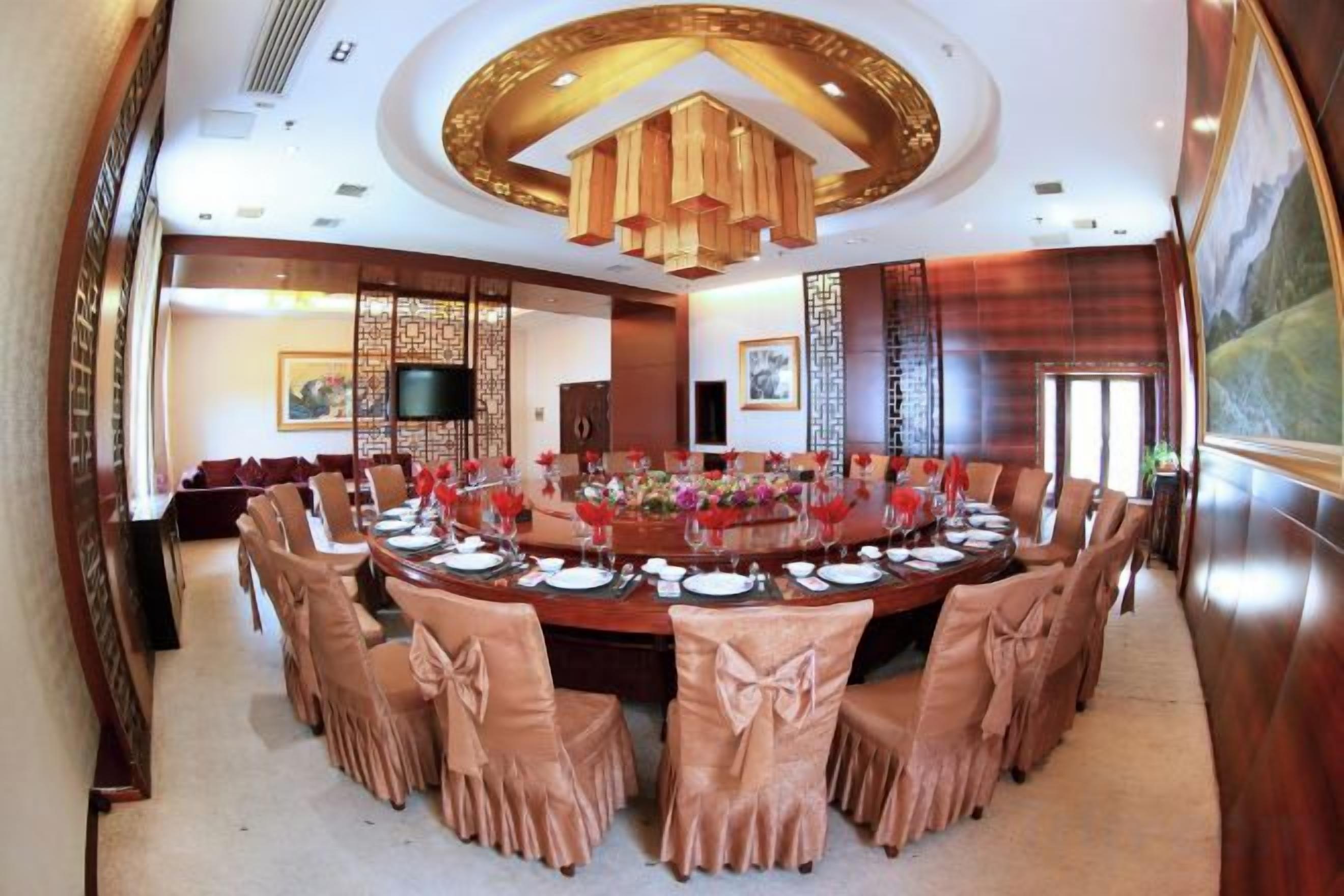 A conference room with a large oval table, chairs, and a television.
