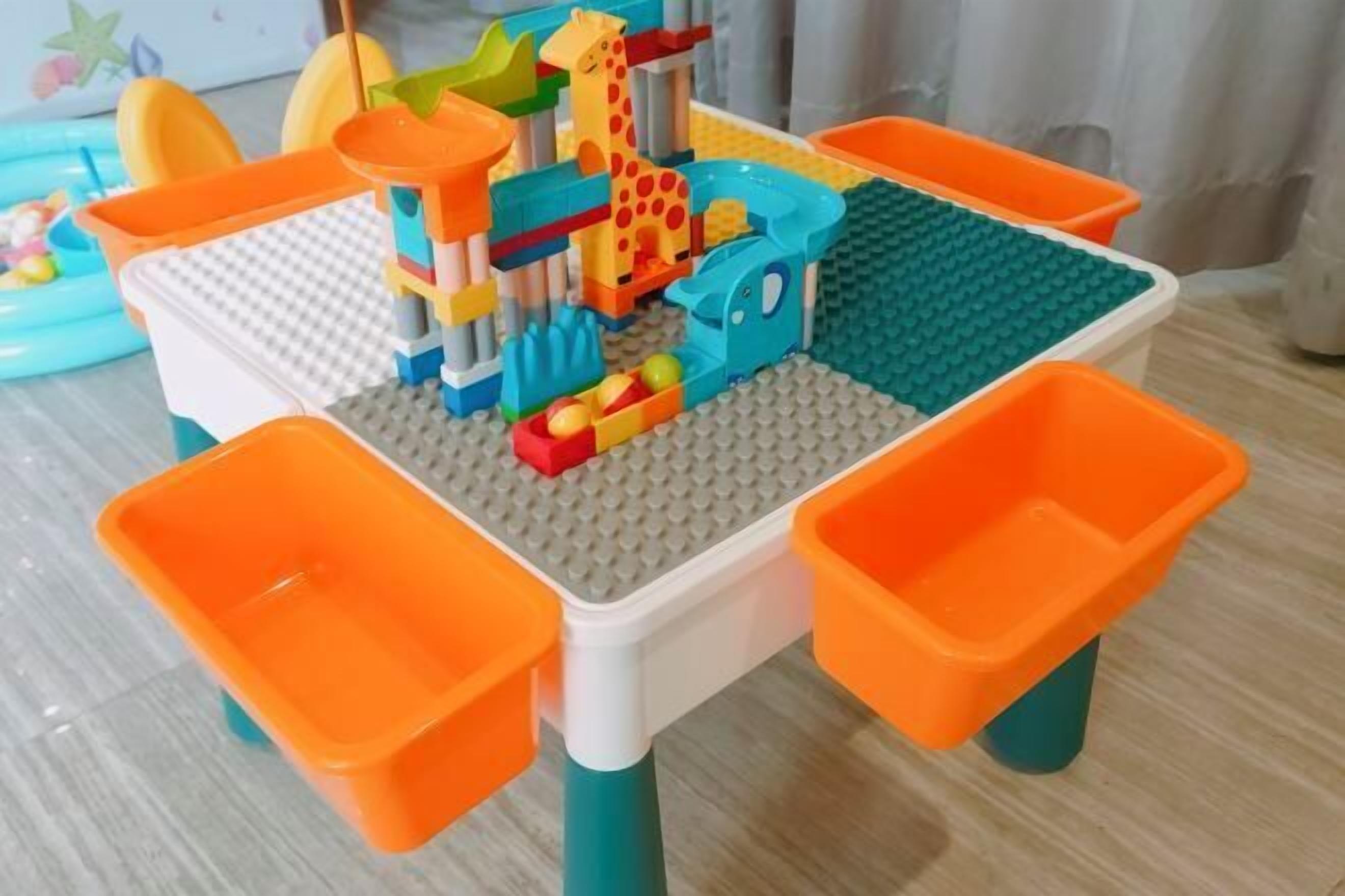 A table with a LEGO play area, featuring a giraffe and other colorful structures.