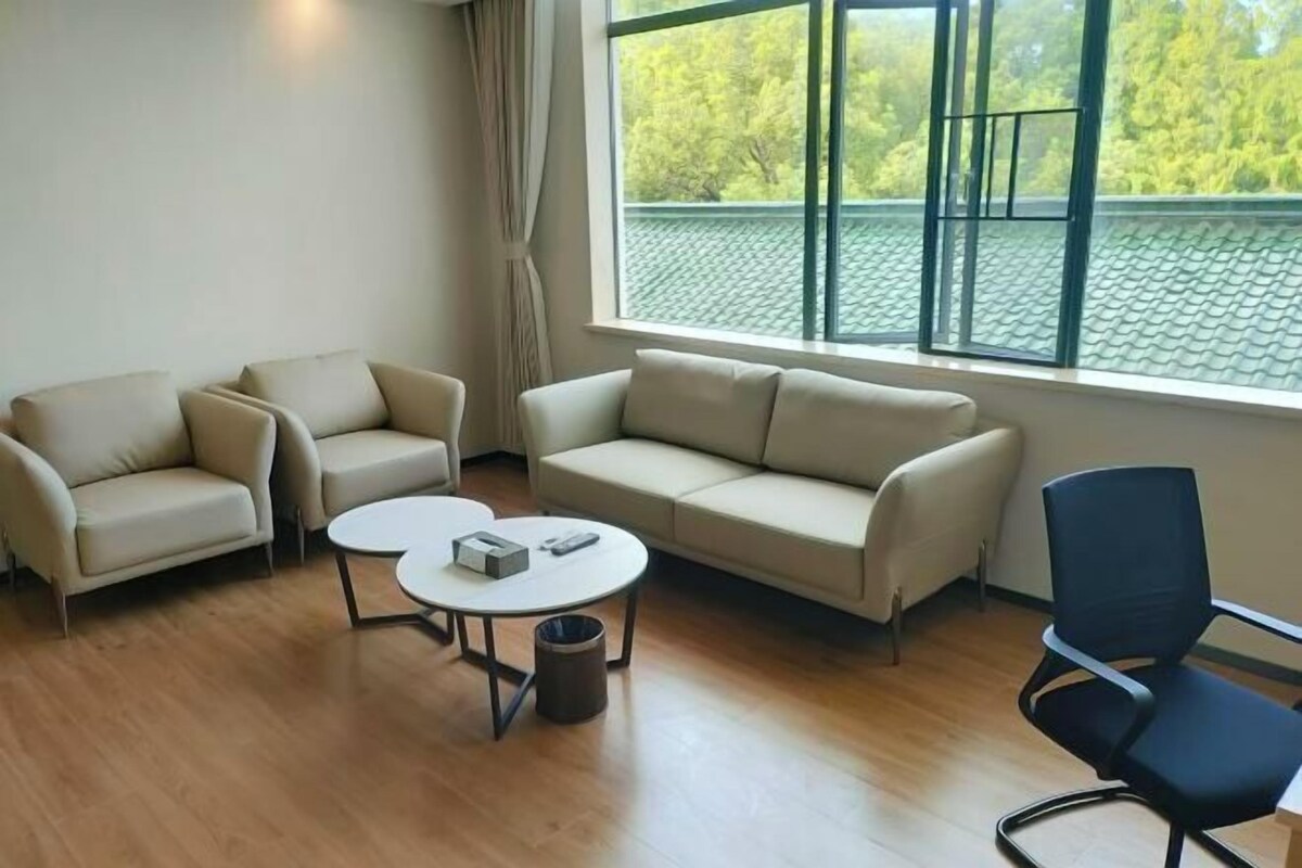 A modern living room with a sofa, two armchairs, a coffee table, and a chair.