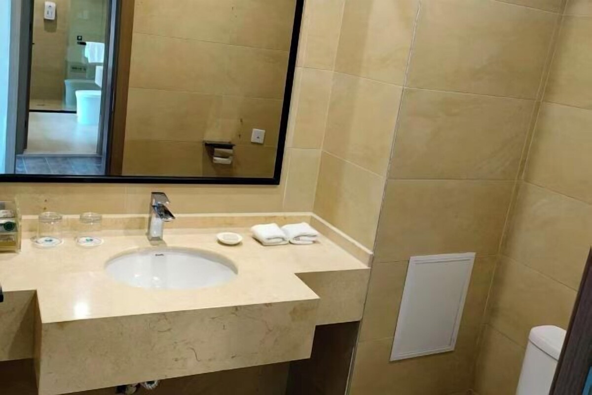 A bathroom with a sink, mirror, and toiletries.