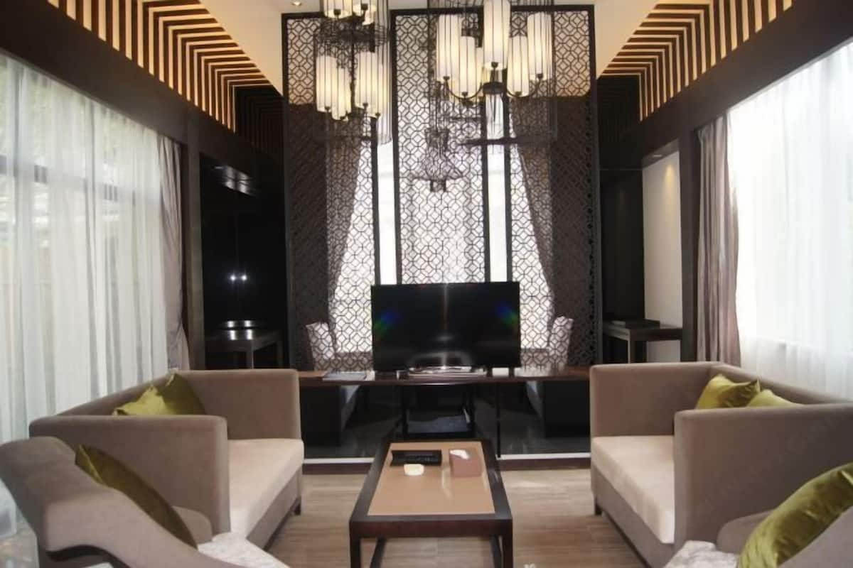Uma sala de estar moderna com televisão, sofás e mesa de centro.
