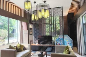 A modern living room with a TV, sofa, and coffee table. - Yichun Jing'an · Changlv Qinlu Jiuling Hot Spring Hotel (Kuangzhong Garden) (Jing'an)