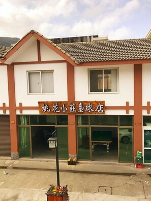 A two-story building with a signboard, windows, and a door. - Zhoushan Tahua Xiaozhuang Impression Hotel (Zhoushan)