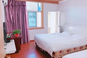 A bedroom with a bed, a desk with a plant, and a window with curtains. - Zhoushan Tahua Xiaozhuang Impression Hotel (Zhoushan)