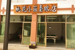 A building with a signboard, large windows, and a staircase leading to an entrance. - Zhoushan Tahua Xiaozhuang Impression Hotel (Zhoushan)