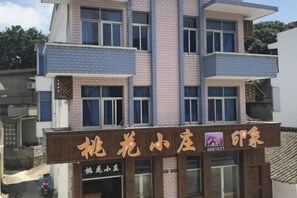 A multi-story building with a signboard indicating a hotel. - Zhoushan Tahua Xiaozhuang Impression Hotel (Zhoushan)
