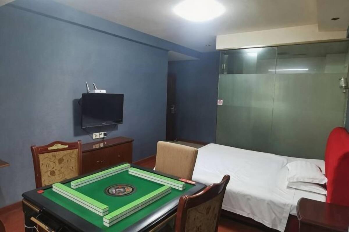 Une chambre d’hôtel comprenant un lit, une télévision, un bureau avec un jeu de société et une chaise.