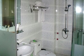 Une salle de bain avec une douche à parois de verre, des toilettes et un lavabo.