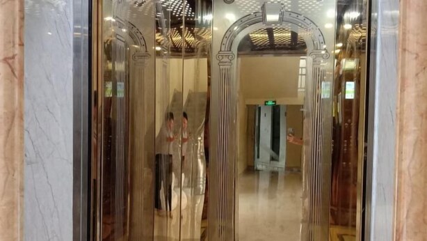 An elevator with marble walls and a glass door. - Green Island Hotel (Daxin)