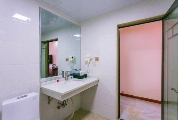 A bathroom with a white sink, a mirror, and a toilet. - Hande Hotel (Baise)