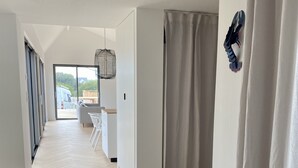 Un pasillo amplio con suelo de madera que conduce a un área de descanso con vistas al exterior.