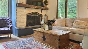 A cozy living room with a fireplace, a sofa, a chair, and a coffee table.