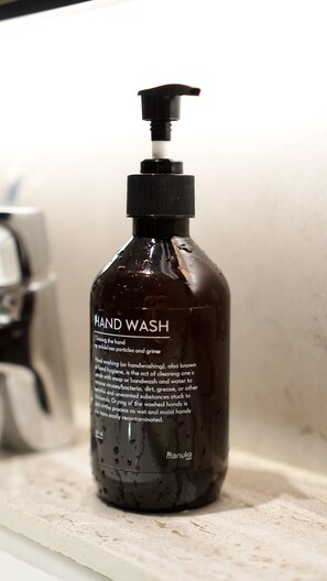 A hand wash bottle with a pump dispenser on a bathroom counter. - Manuka By Havis Hotel at Penuin (Batam)