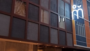 A modern building with a prominent 'manuka' sign, large windows, and a visible entrance. - Manuka By Havis Hotel at Penuin (Batam)