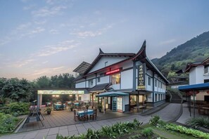 A traditional building with a restaurant and outdoor seating area. - Mingxiuya Leisure Villa (Emeishan City)