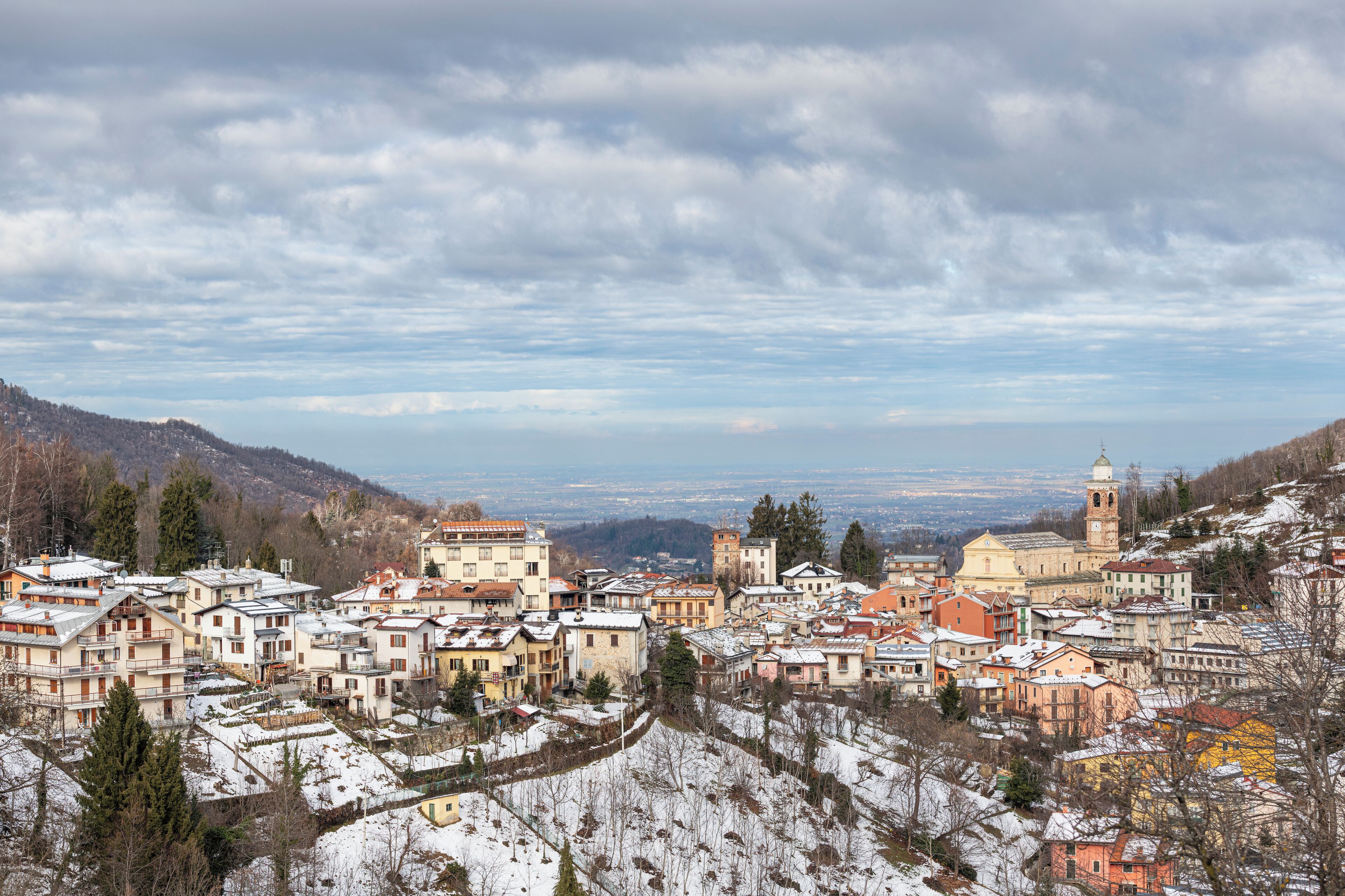 A snow-covered town with historic buildings and a prominent church tower.
