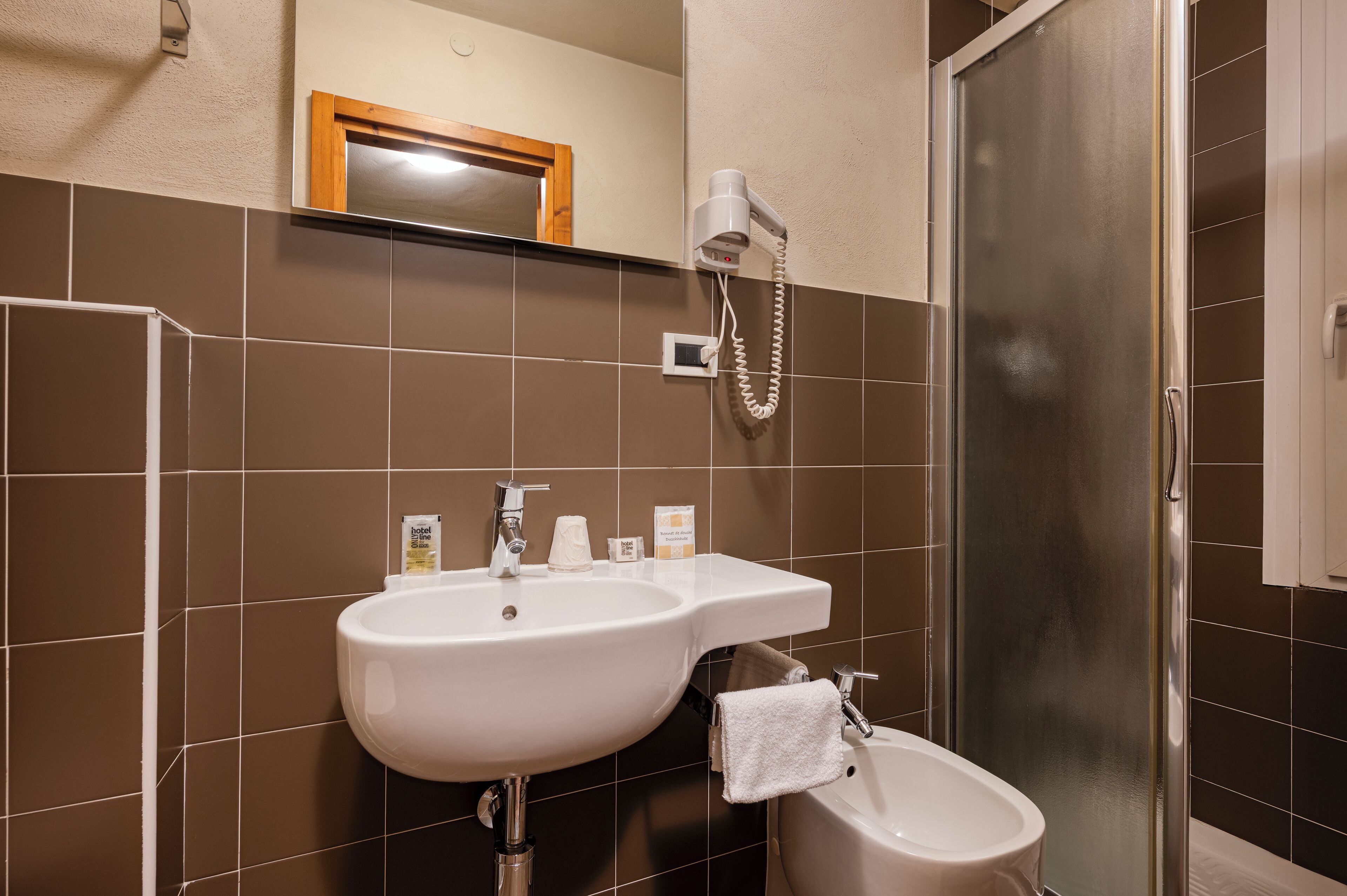 A bathroom with two sinks, a mirror, and a shower.