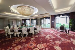 A spacious room with a pool table, multiple chairs, a chandelier, and large windows. - Dongjiang Holiday Hotel (Danyang)