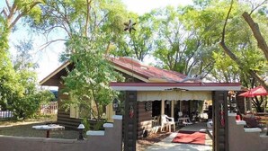 Eine Blockhütte mit Veranda, umgeben von Bäumen.