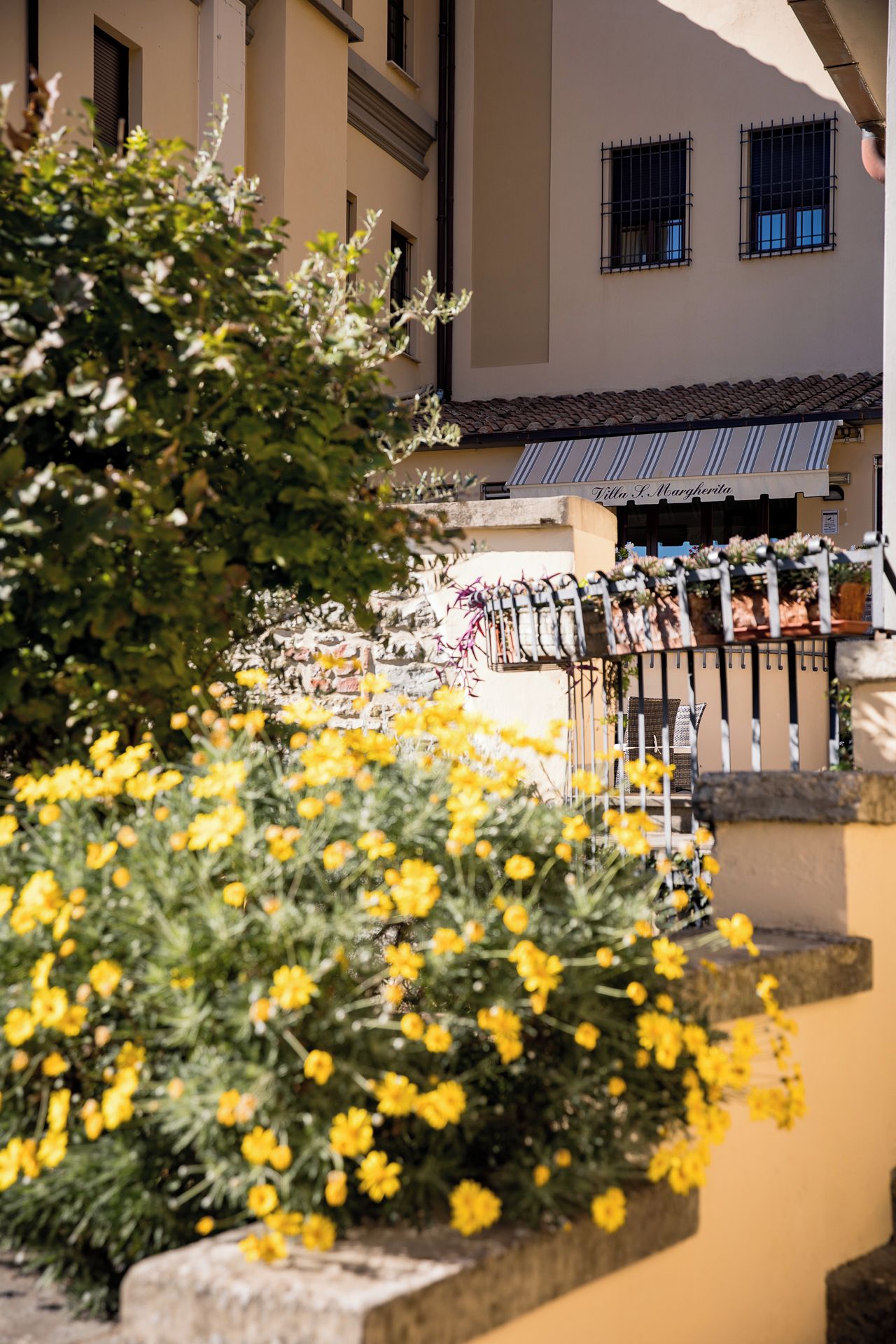 A building with a sign that reads 'Villa L. Margherita' and a staircase leading to a balcony with a railing.