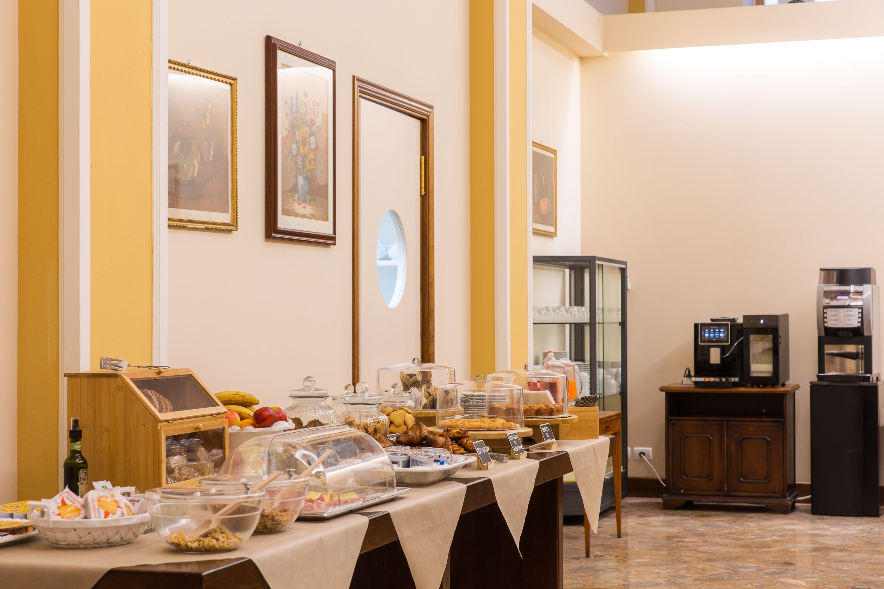 Montaje de bufé con diferentes opciones de comida y una máquina de café.