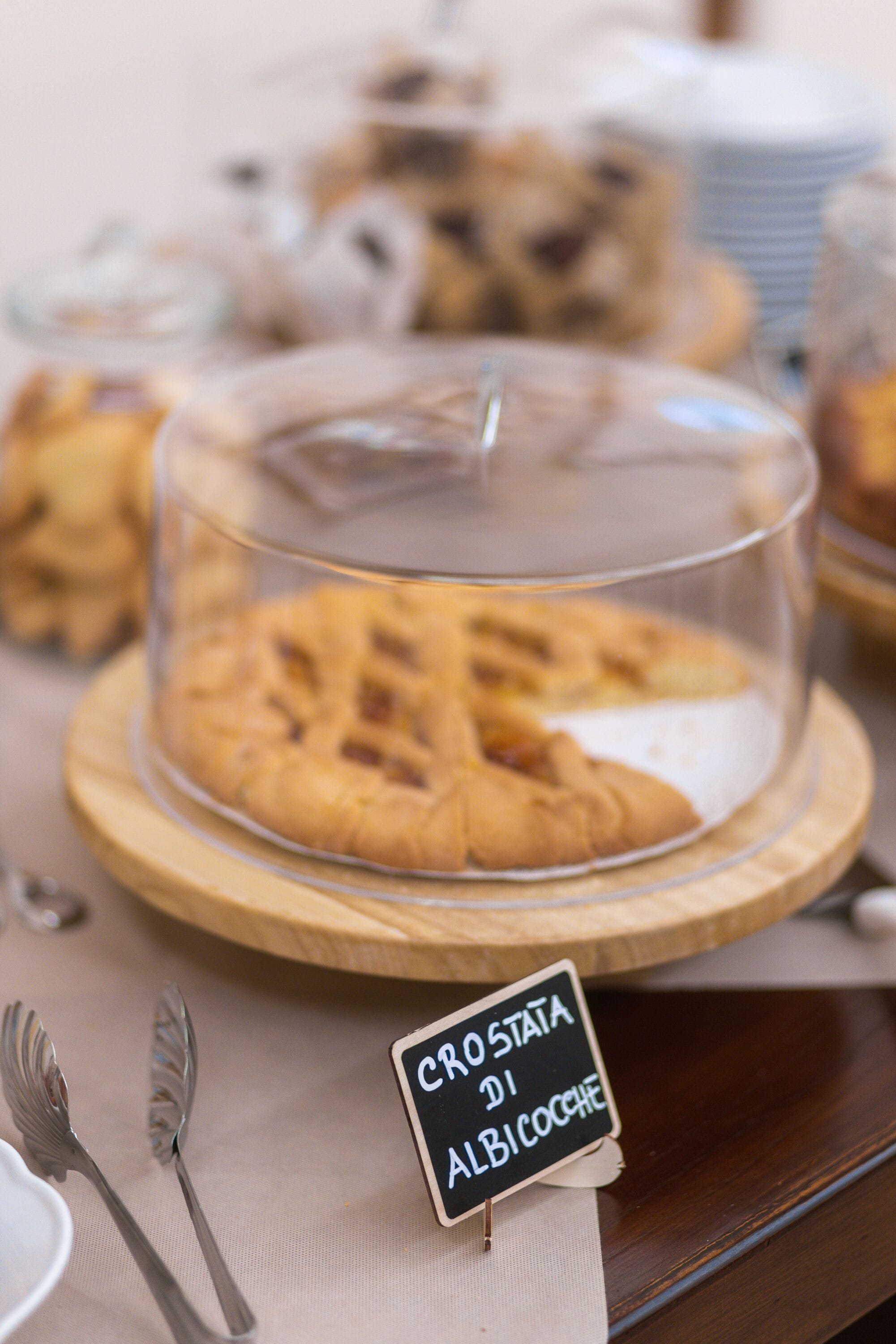 A dessert display with a sign reading "Crosta di Albicocche".