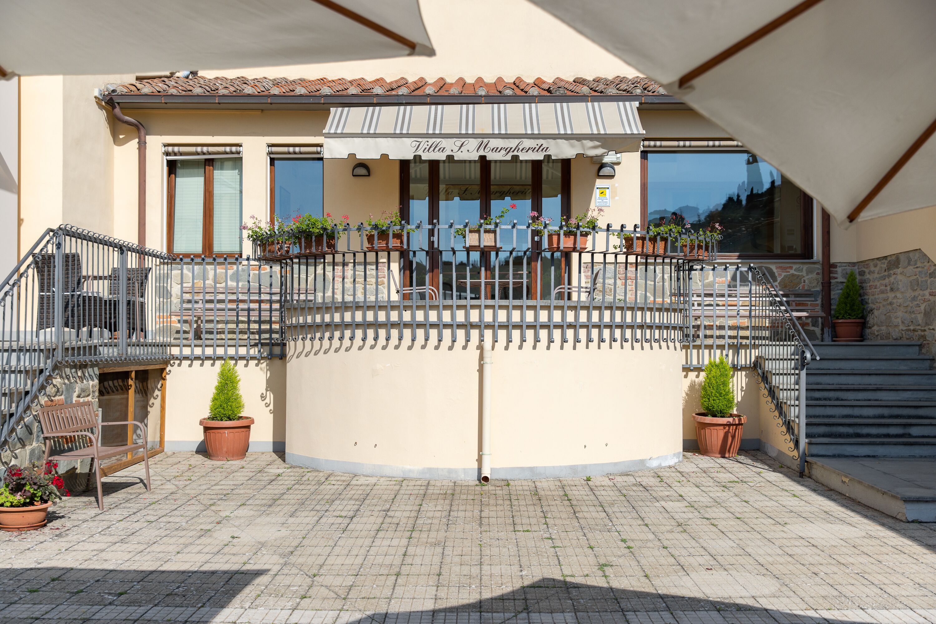 Ein Gebäude mit Ziegeldach, einem Balkon mit Blumentöpfen und einem Schild mit der Aufschrift 'Villa S. Margherita'.