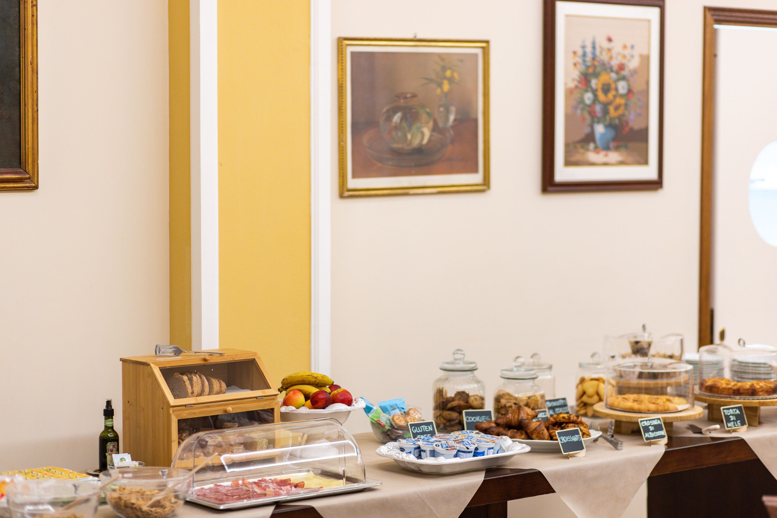 Une table de buffet proposant divers plats et des récipients étiquetés, notamment des options sans gluten.