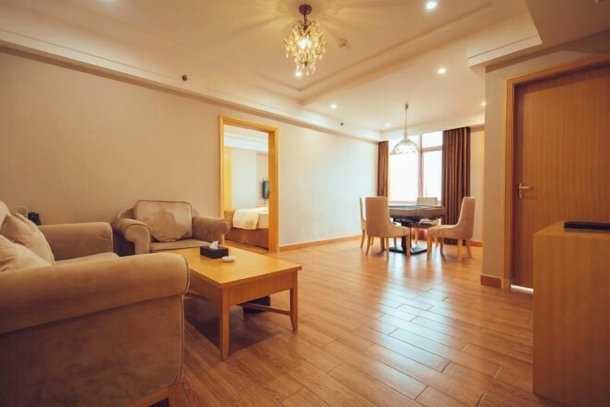 A spacious living room with a sofa set, a coffee table, and a dining area with chairs.