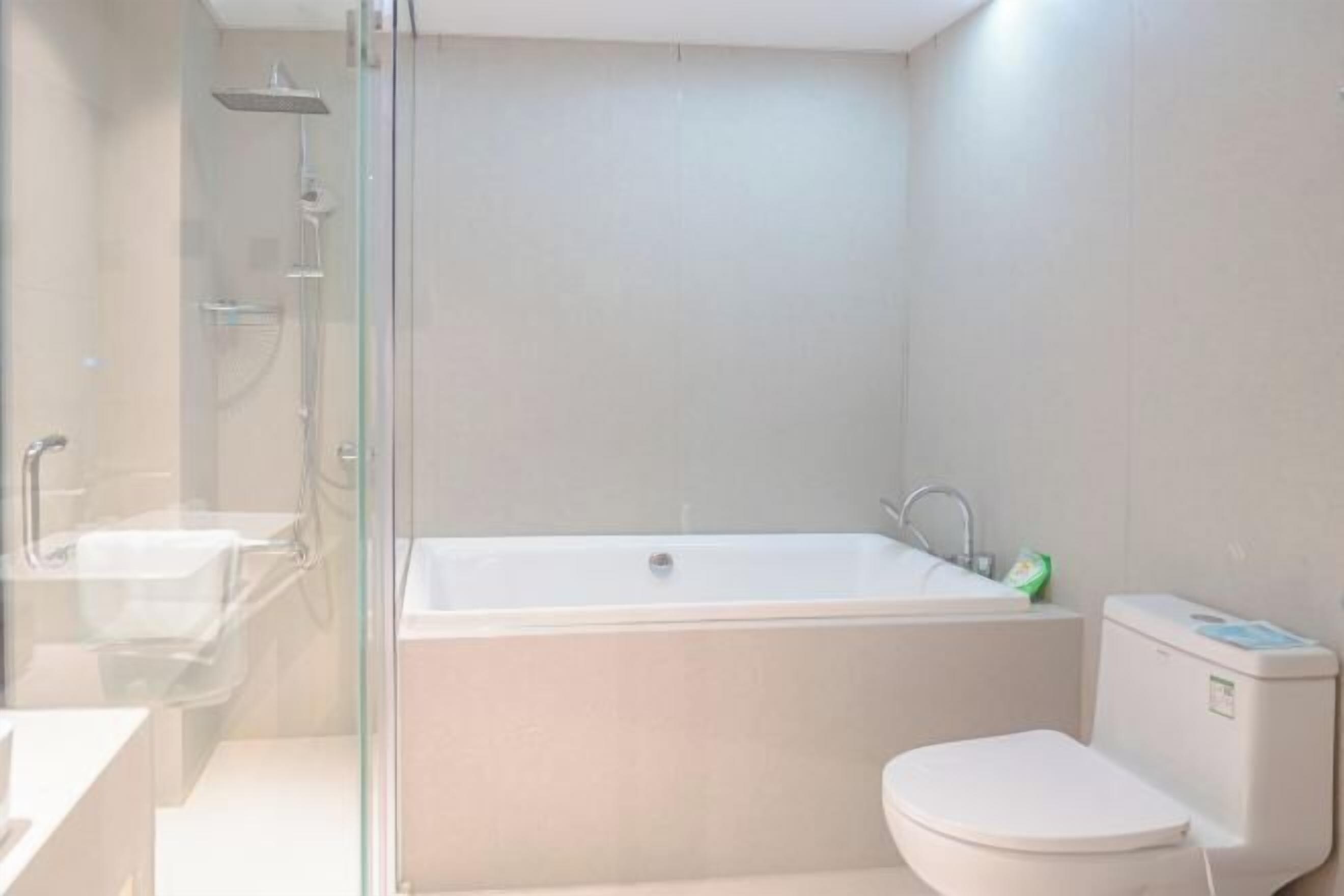 A modern bathroom with a glass-enclosed shower, a standalone bathtub, and a toilet.