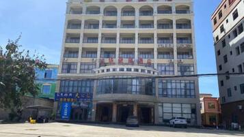 A multi-story building with a central entrance, large windows, and signage indicating it is a hotel.