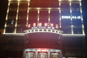 A building with illuminated signage, a curved entrance, and a series of vertical light fixtures. - Ledong Fuhua Haoting Hotel (Huangliu Branch) (Ledong)