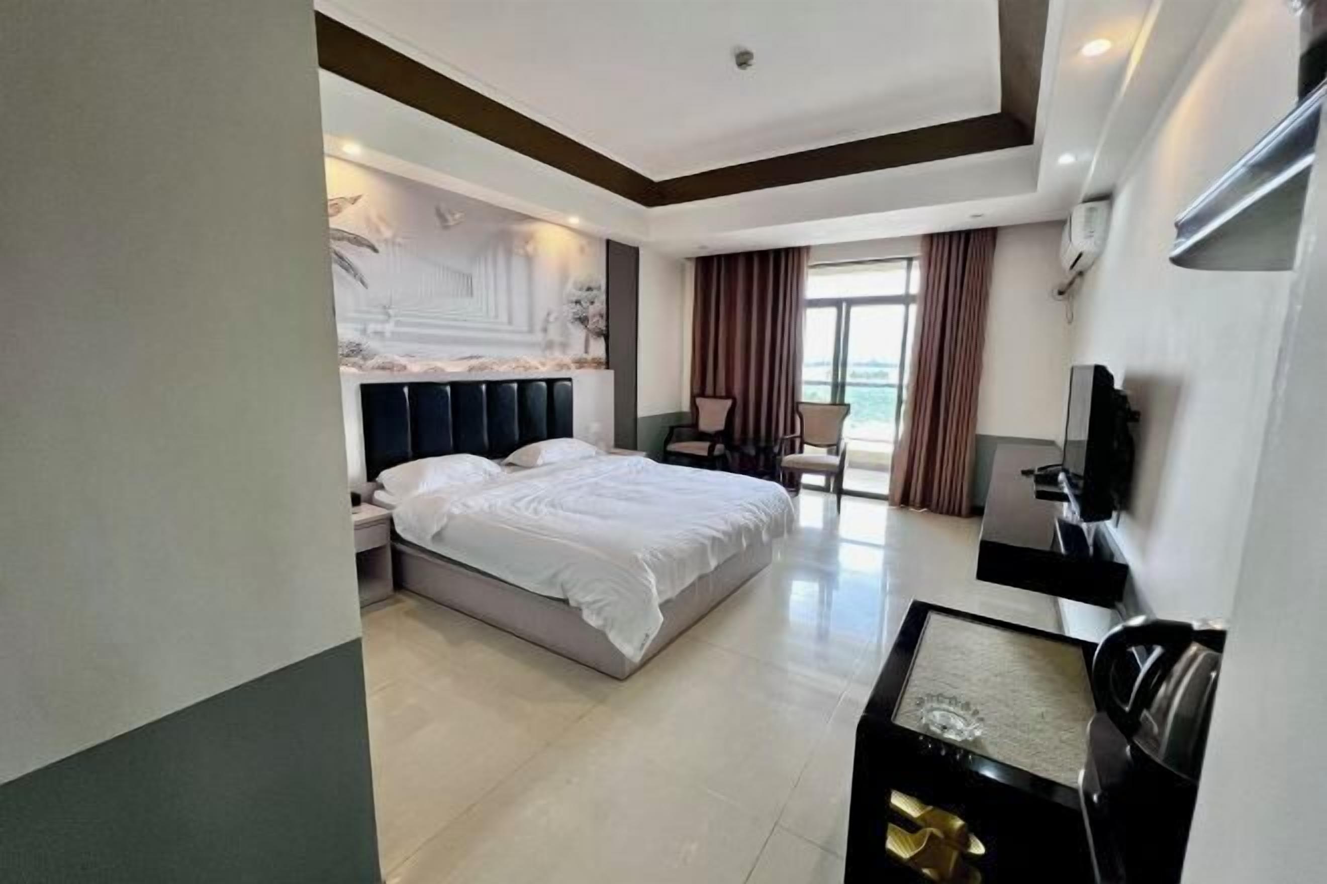 Une chambre d’hôtel moderne équipée d’un grand lit, d’un bureau, d’une chaise et d’un téléviseur.