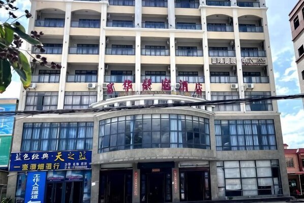 A multi-story hotel with a curved facade, large windows, and a sign indicating it is a hotel. - Ledong Fuhua Haoting Hotel (Huangliu Branch) (Ledong)