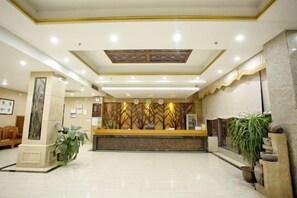 A hotel lobby with a reception desk, a large plant, and a decorative wall. - Ledong Fuhua Haoting Hotel (Huangliu Branch) (Ledong)