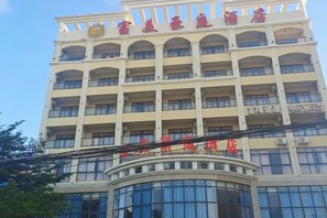 A multi-story hotel with a prominent red sign at the top. - Ledong Fuhua Haoting Hotel (Huangliu Branch) (Ledong)