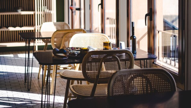 An outdoor seating area with wicker chairs and tables, large arched windows, and a wooden ceiling. - ORA Hotel Priorat, a Member of Design Hotels (Torroja del Priorat)