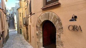 A narrow cobblestone street with a stone archway leading to a building labeled "ORA". - ORA Hotel Priorat, a Member of Design Hotels (Torroja del Priorat)