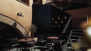 An outdoor seating area with tables and chairs, a potted plant, and a staircase. - ORA Hotel Priorat, a Member of Design Hotels (Torroja del Priorat)