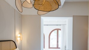 A bedroom with a large bed, a rattan ceiling light, and a view of the outside through a window. - ORA Hotel Priorat, a Member of Design Hotels (Torroja del Priorat)