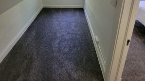 A small, dimly lit room with a slanted ceiling, a single window, and a door. - The Lakeside Micro Apartment (Muskegon)