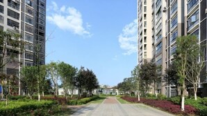 A pathway flanked by trees and buildings, leading to a distant structure. - Huaxi Guesthouse (Zhangjiajie)