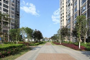 A pathway flanked by trees and buildings, leading to a distant structure. - Huaxi Guesthouse (Zhangjiajie)