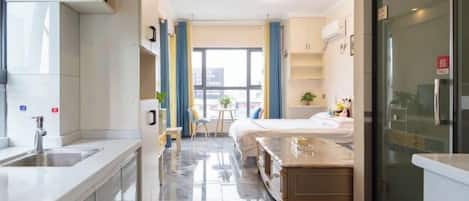 Une chambre d’hôtel moderne équipée d’un coin cuisine, d’une table à manger et d’un lit.