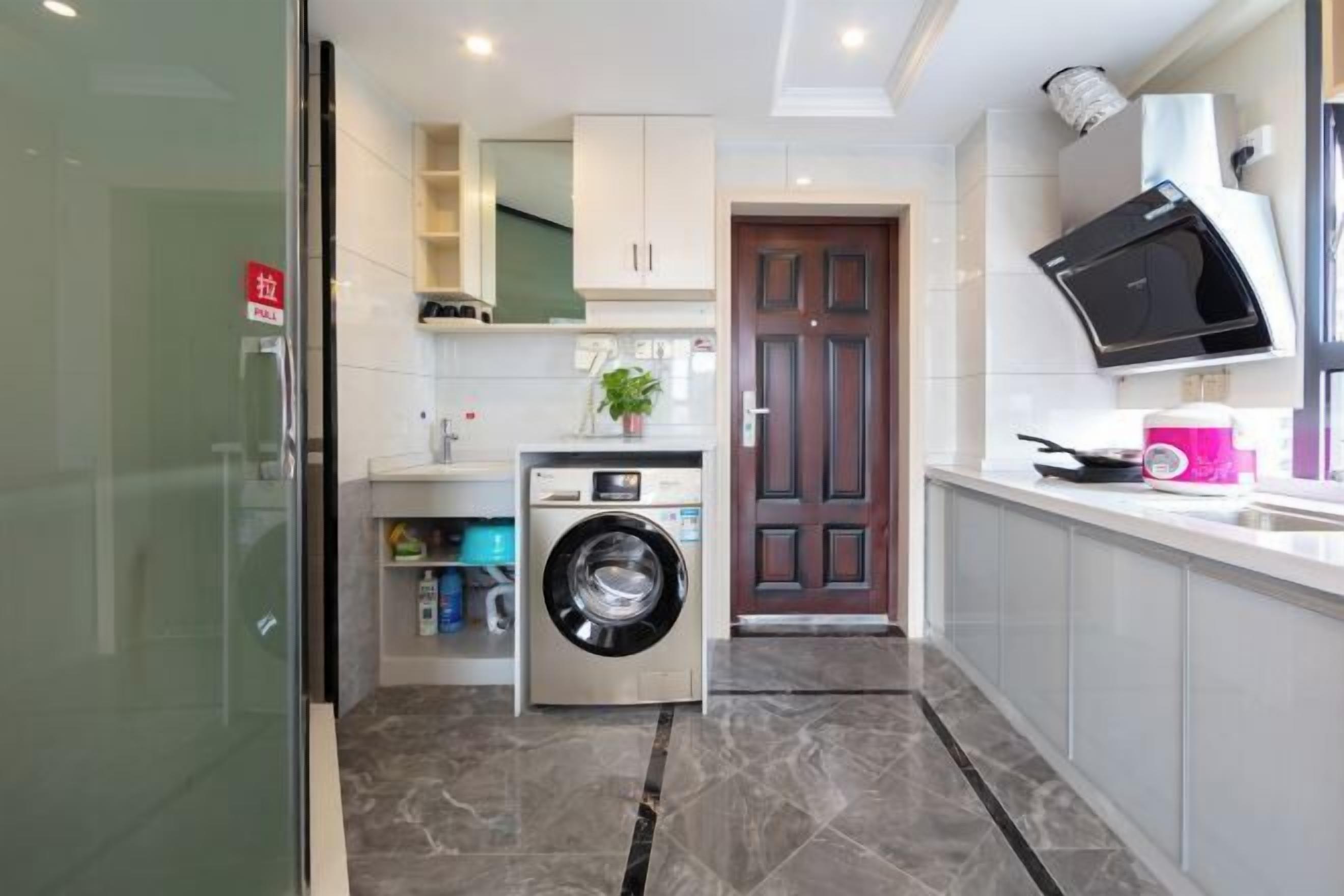 A compact kitchen with a built-in washing machine, a microwave, and a sink.