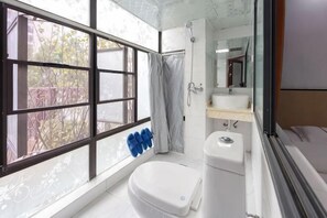 A bathroom with a toilet, sink, and shower. - Huaxi Guesthouse (Zhangjiajie)