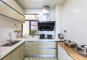 Una cocina compacta con pileta, estufa y alacenas.