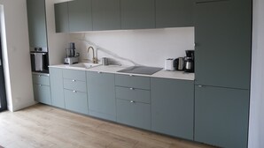 A modern kitchen with grey cabinets, a white countertop, and a hanging pendant light. - house with sea river view, with jacuzzi spa (Gouesnach)