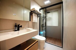 A modern bathroom with a white sink, black faucet, and a glass-enclosed shower. - Lost&Found@Wutong House (Shenzhen)