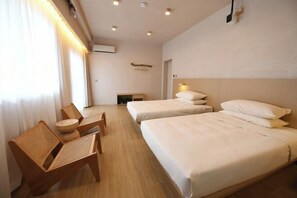 A hotel room with two beds, a wooden chair, a small table, and a ceiling light fixture. - Lost&Found@Wutong House (Shenzhen)